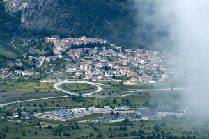 Laboratorium Narodowe Gran Sasso (kompleks naziemny) na tle miejscowości Assergi we włoskich Apeninach 